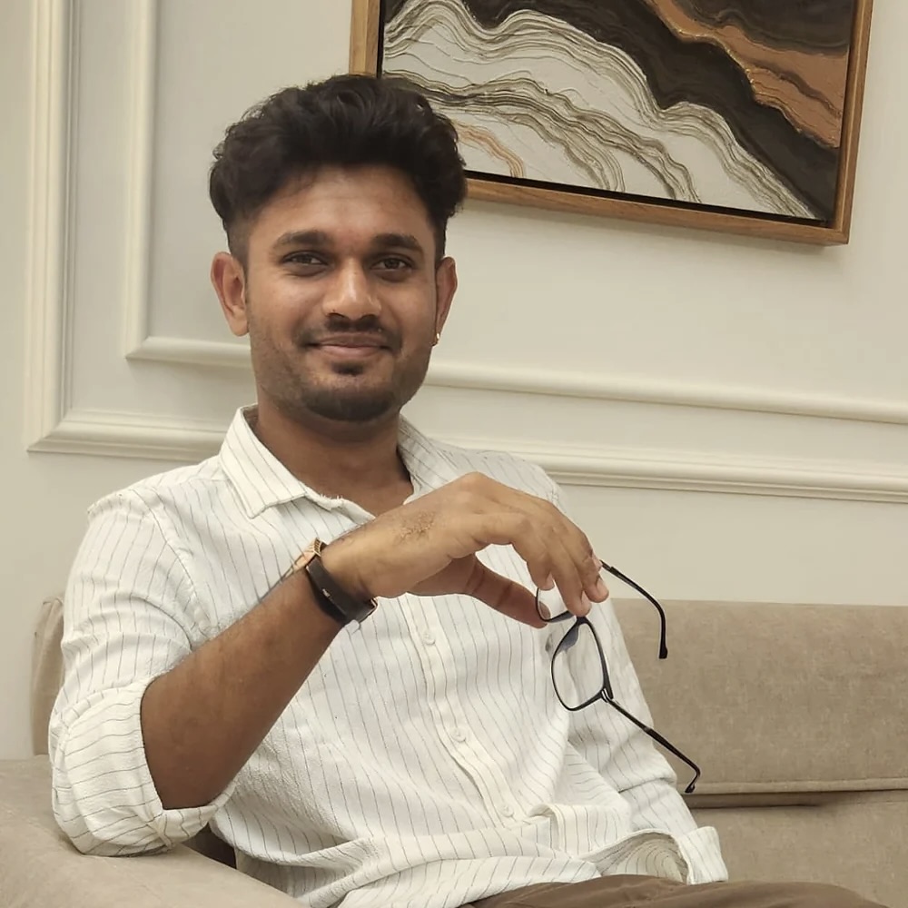 Vatsal Vaghasiya, seated, holding his glasses